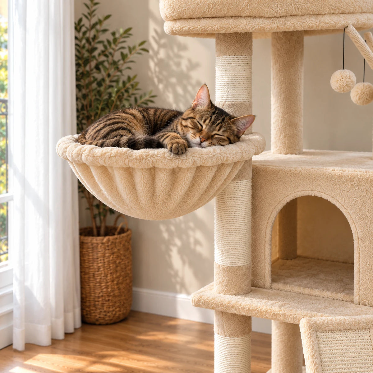 Chat tigré endormi dans le hamac beige de l’arbre à chat Oat