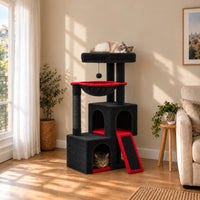 Arbre à chat Ember noir et rouge dans un salon avec deux chats endormis dans la niche basse et sur le perchoir