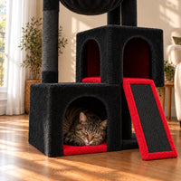 Chat endormi dans la niche basse rouge de l’arbre à chat Ember, détail de la rampe à griffer noire